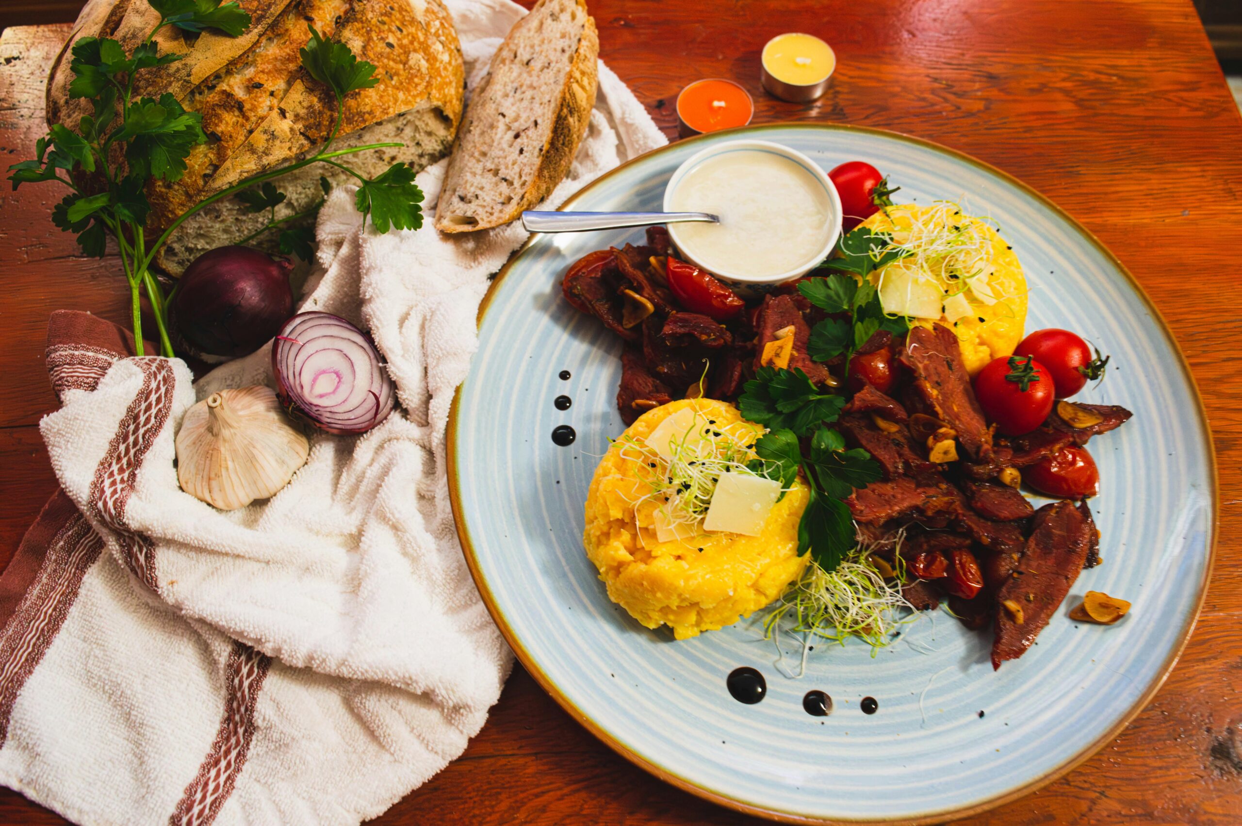 Delicious Romanian cuisine featuring polenta, vegetables, and artisan bread in a vibrant setting.