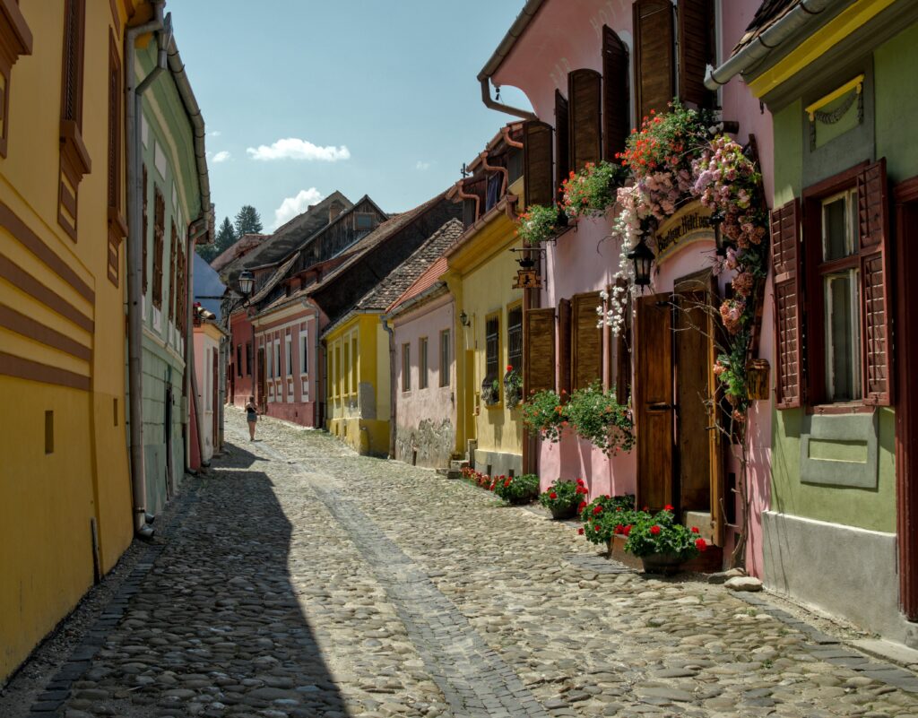 Picturesque old street with colorful medieval buildings in Sighișoara, Romania.