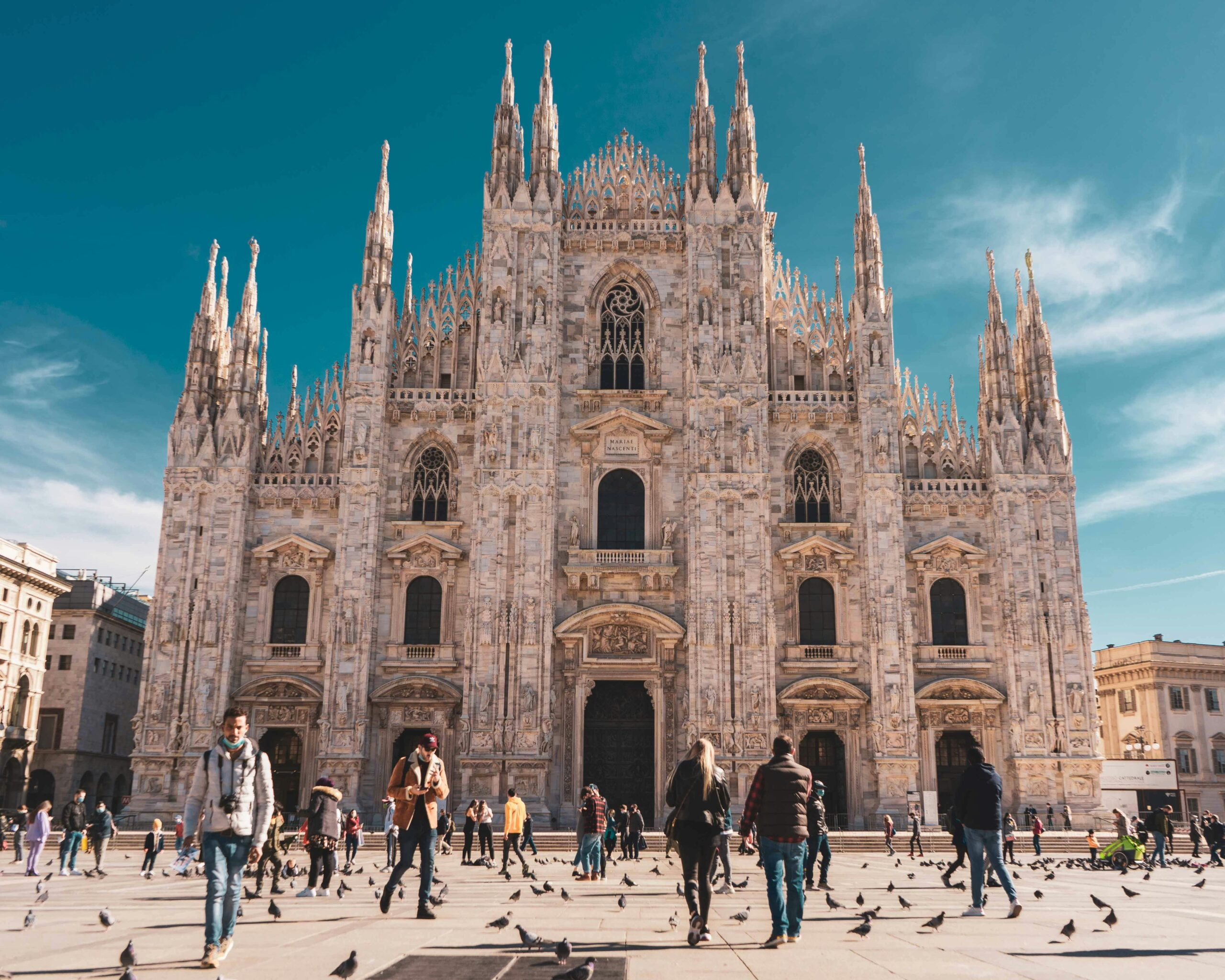 Tourists visit the iconic Duomo di Milano, showcasing its detailed Gothic architecture.