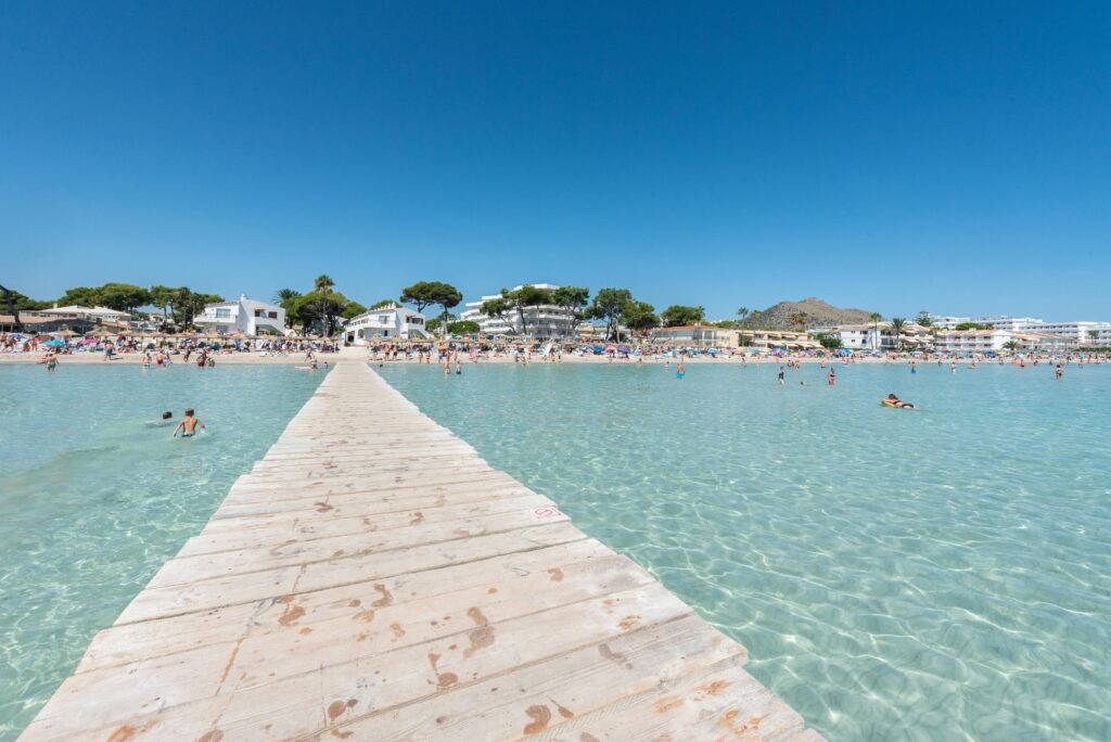 Wooden pier at Alcudia Beach with clear shallow water